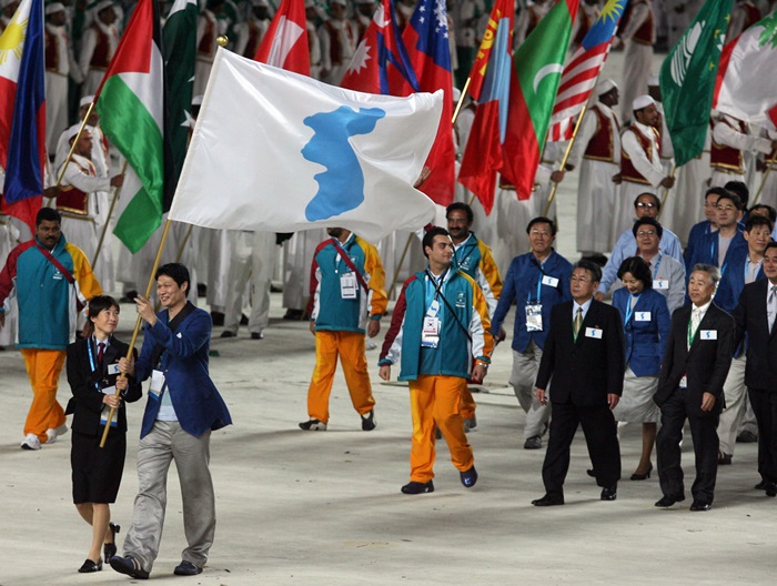 Jointly carrying a unified Korean flag, Lee Kyu-sup (R), a South Korean male basketball player, and Ri Kum-suk (L), a North Korean female footballer, march together on Dec. 1, 2006, at the opening ceremony of the Asian Games in Qatar.